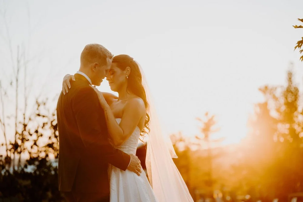 Kylie and Will forehead to forehead against a glowing sunset near Ottawa