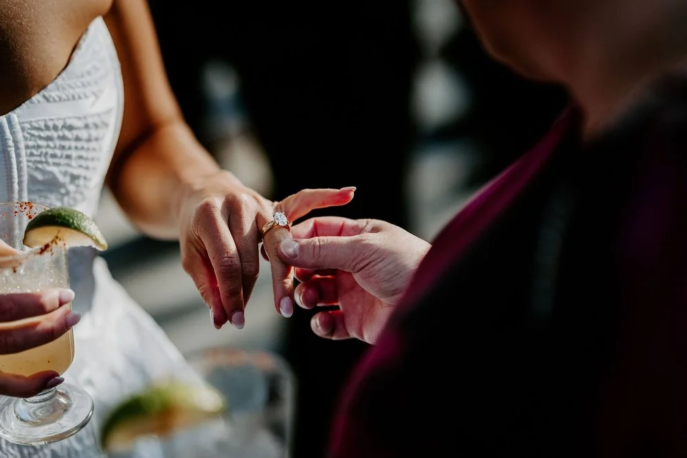 A guest admiring Kylie's engagement ring during cocktail hour