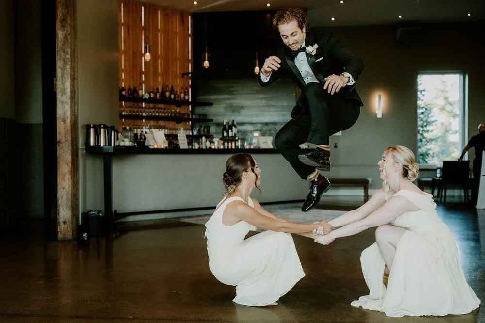 A groomsman leaping over two bridesmaids during the wedding party's grand entrance at Le Belvedere