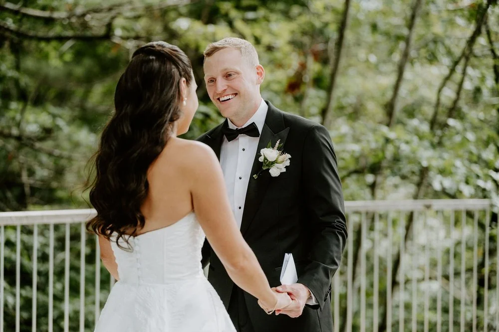 Will beaming as he holds Kylie's hands and his vow card on the deck at Le Belvedere