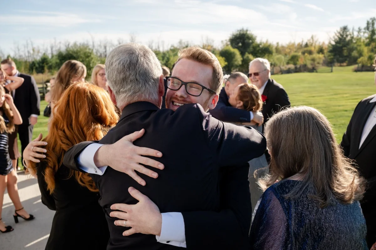 family members hugging a celebrating after a wedding ceremony