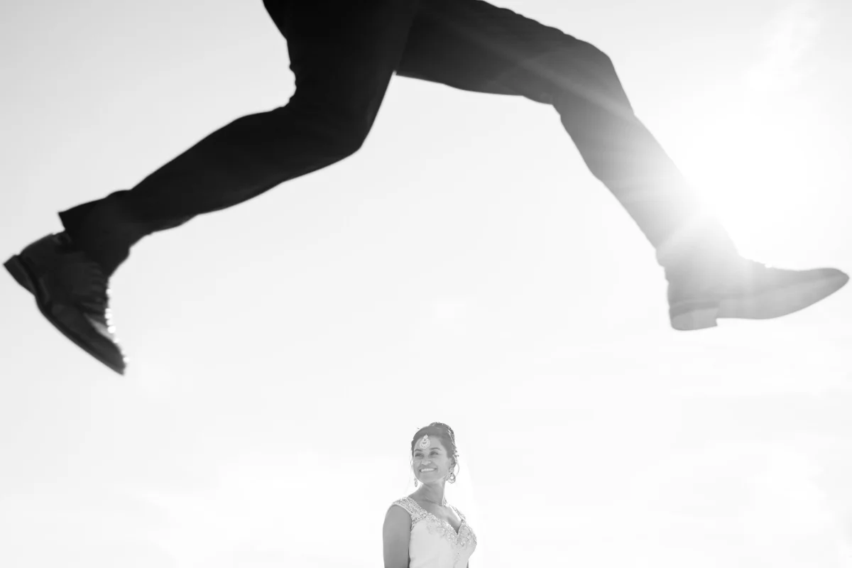 Groom jumping in front bride at le belvedere in Wakefield