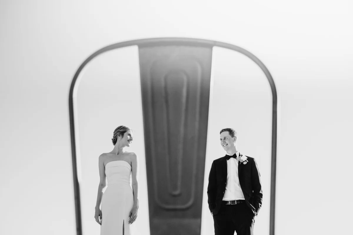 bride-and-groom-pose-for-photo-at-le-belvedere-between-a-chair-in-wakefield-quebec.JPG