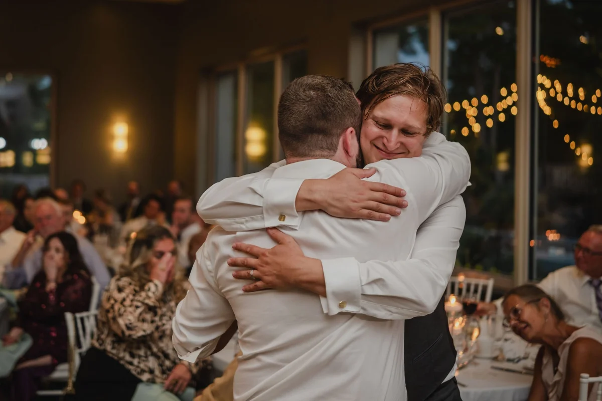 groom hugging a wedding guest
