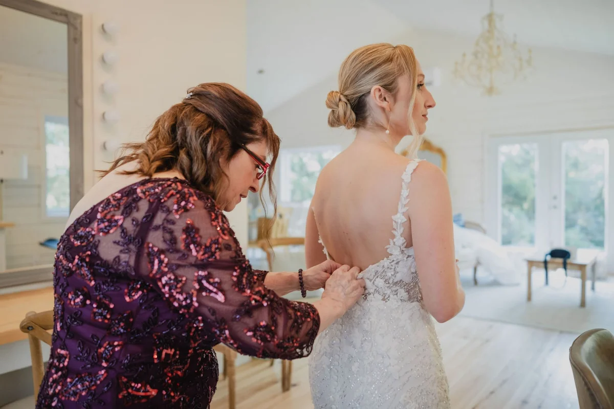 a bride getting her wedding dress done up