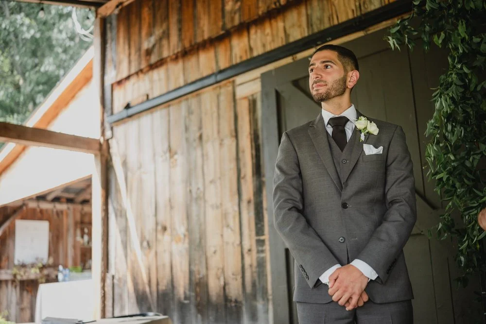 a groom waiting a the front to the aisle for his bride