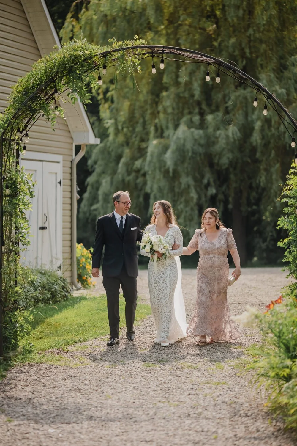 photograph of a bride walking down the aisle at her Adelina barn wedding