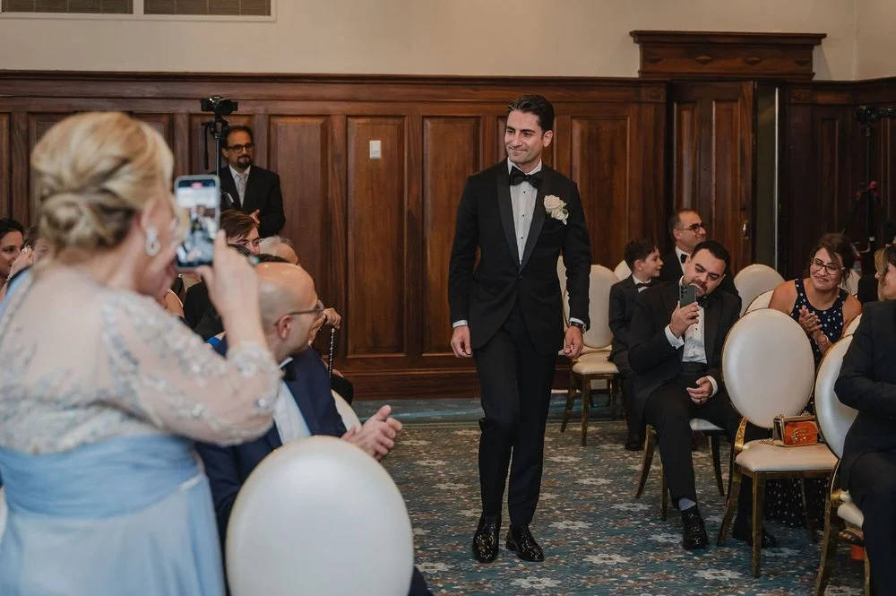 photograph of a groom walking down the aisle at his wedding