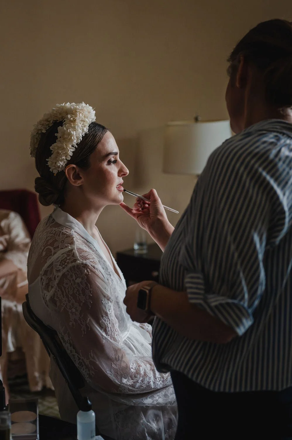 photograph of a bride getting her makeup done inside a suite at the chateau laurier