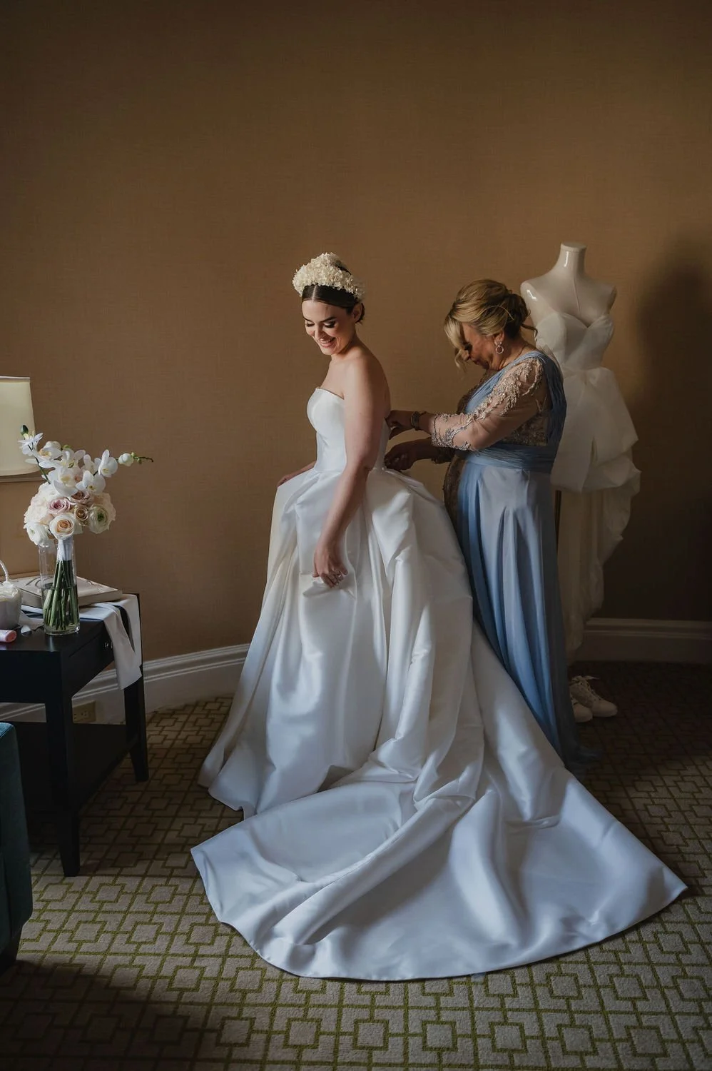 bride getting into her wedding dress in a suite at the chateau Laurier in ottawa