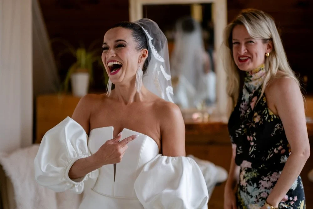 a bride laughing while getting ready for her wedding at Temple's Sugar Bush