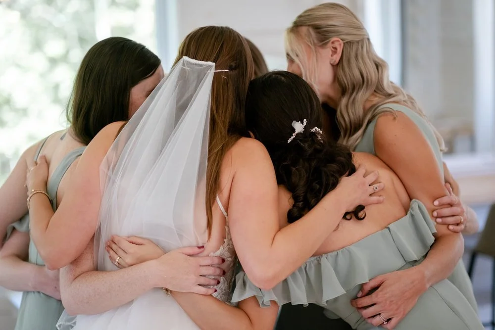 Bride hugging her bridesmaids