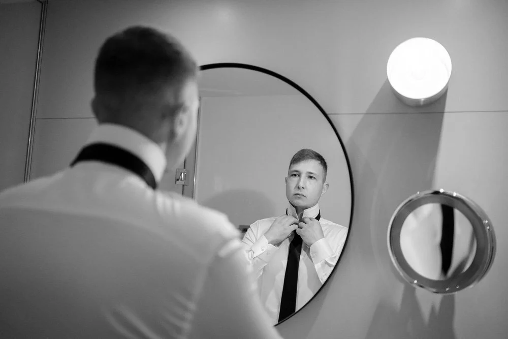 Black and white photo of groom getting ready for his wedding