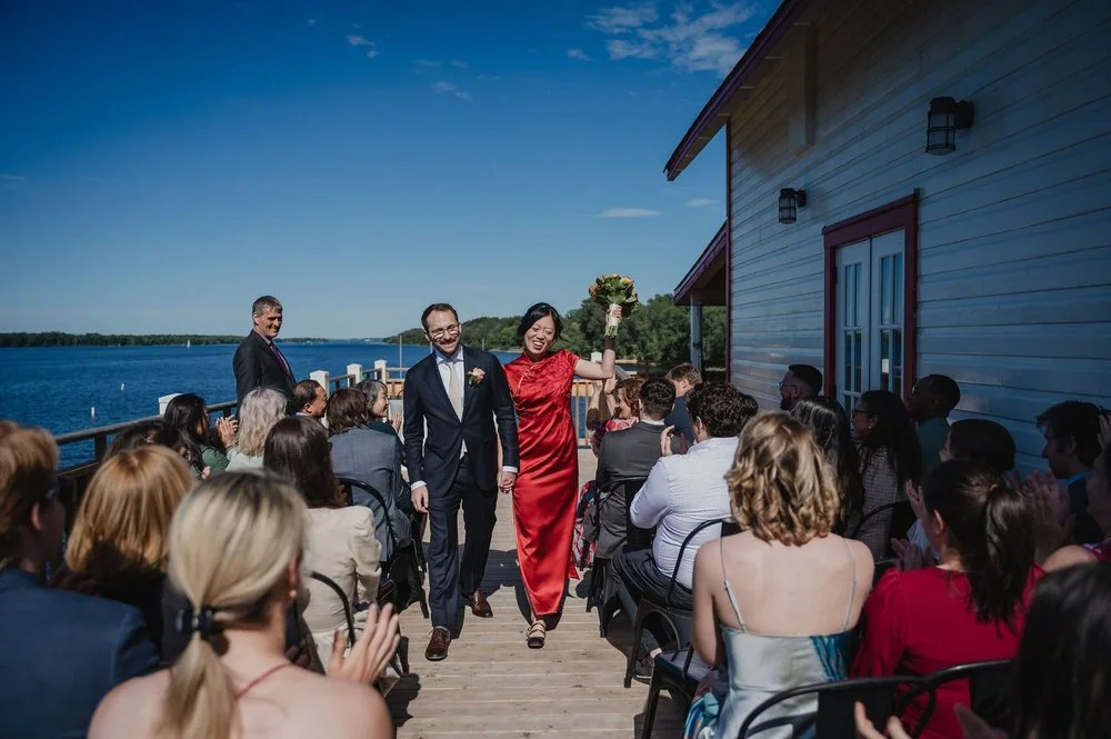 a bride and groom walk down the aisle after their wedding ceremony at the NCC River House