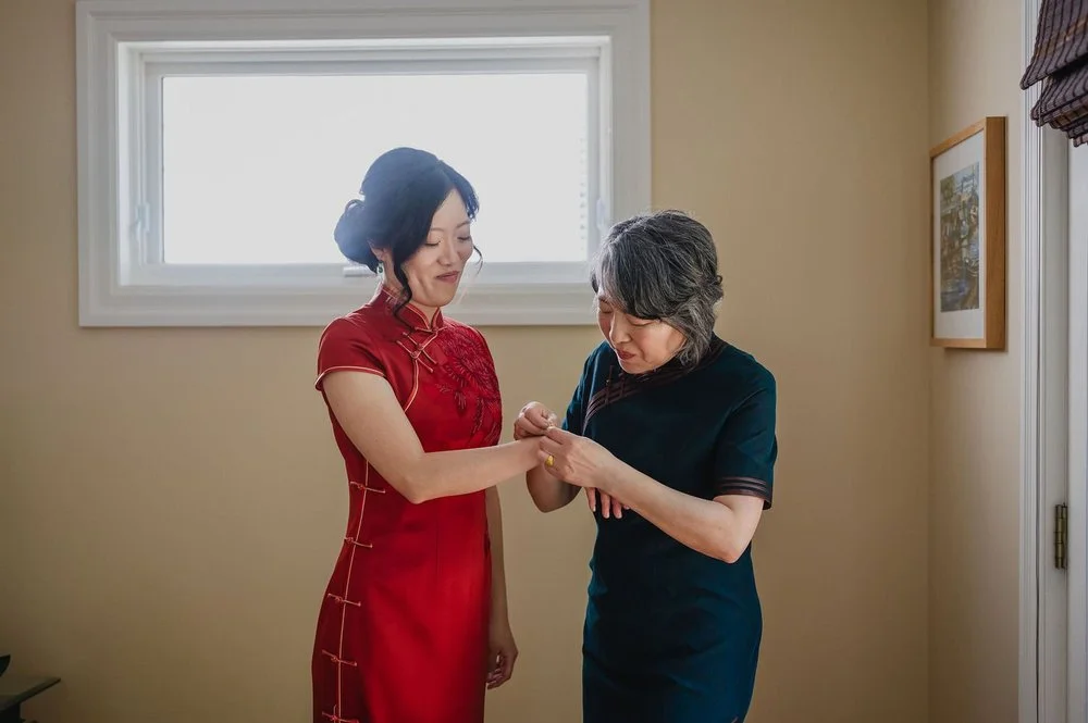 A bride's mother helps her get ready for her wedding